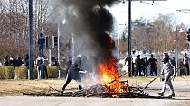 La gente quema ramas para bloquear una carretera durante unos disturbios en Norrkoping, Suecia, el domingo 17 de abril de 2022