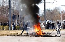 La gente quema ramas para bloquear una carretera durante unos disturbios en Norrkoping, Suecia, el domingo 17 de abril de 2022