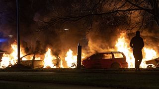 Cars are engulfed by flames after protests broke out at Rosengard in Malmo.