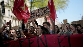 A demonstrator hols a board reading: 'neither Macron nor Le Pen', during a protest against far-right in Paris, Saturday, April 16, 2022.