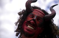 Un homme masqué dansant lors du traditionnel carnaval de la culture noire "Feira das Yabas" dans la banlieue de Rio de Janeiro, au Brésil, dimanche 17 avril 2022.