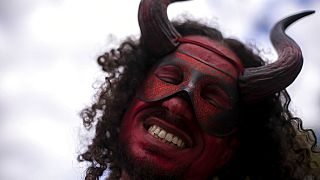 Un homme masqué dansant lors du traditionnel carnaval de la culture noire "Feira das Yabas" dans la banlieue de Rio de Janeiro, au Brésil, dimanche 17 avril 2022.