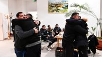 Unos hombres se abrazan tras reencuentro en un refugio temporal para ucranianos en un centro de Zahony, Hungría, cerca de la frontera con Ucrania, el 25 de febrero de 2022.