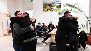 Unos hombres se abrazan tras reencuentro en un refugio temporal para ucranianos en un centro de Zahony, Hungría, cerca de la frontera con Ucrania, el 25 de febrero de 2022.