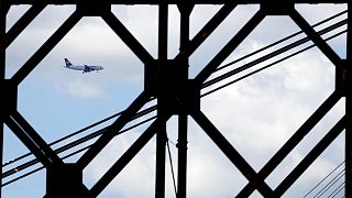 An Air Serbia passenger plane flies over the "Old Railroad Bridge" over the Sava river.