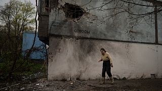 سيدة أوكرانية تسير وسط الحطام في خاركيف