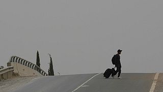 A migrant crosses a street with a suitcase, near the Pournara Emergency Reception center, in Kokkinotrimithia, on the outskirts of the capital Nicosia, Cyprus, April 11.