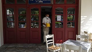 Görög üzletvezető boltja bejáratánál