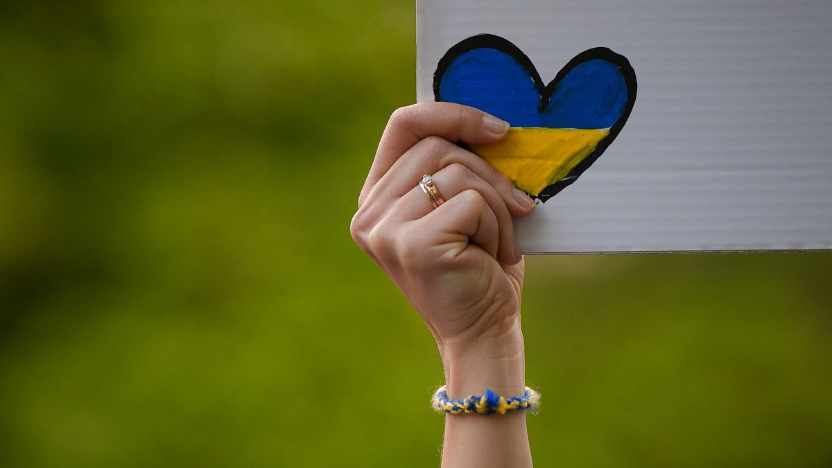 Une personne brandissant un cœur aux couleurs de l'Ukraine lors d'une manifestation devant l'ambassade russe à Bucarest, en Roumanie, le 16 avril 2022 