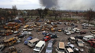 Поврежденные и сгоревшие автомобили на разрушенной части завода им. Ильича. Дым над комбинатом "Азовсталь".