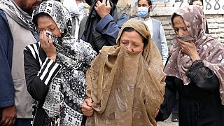 Les familles de victimes des explosions qui ont eu lieu devant une école à Kaboul, en Afghanistan, mardi 19 avril 2022.