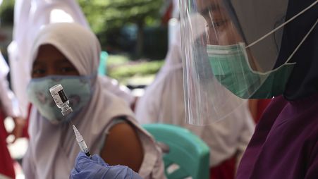 A health workers prepares an HPV vaccine shot for a student in Jakarta, Indonesia