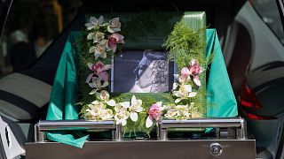 Fotografia de Eunice Muñoz junto da urna com os restos mortais da atriz