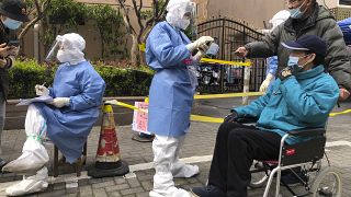 FILE - Workers in protective gear register residents for COVID testing in the Jingan district of western Shanghai, China, Friday, April 1, 2022