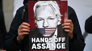 Un manifestant brandissant un portrait de Julian Assange, le 12 avril 2022, devant le tribunal de Westminster Magistrates