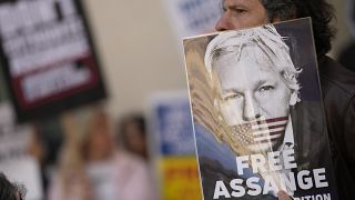 أنصار مؤسس موقع ويكيليكس، جوليان أسانج، يحملون لافتات أثناء تجمعهم خارج محكمة وستمنستر في لندن، الأربعاء 20 أبريل 2022.