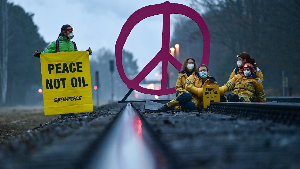 A Greenpeace aktivistái torlaszolnak el egy németországi olajfinomítóhoz vezető vasútvonalat 2022. március 15-én