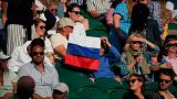 A spectator holding a Russian flag watches during the 2021 Wimbledon Tennis Championships in London.