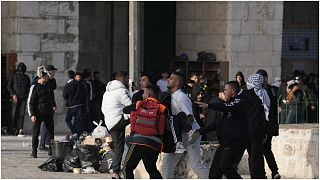  متظاهر فلسطيني أصيب في اشتباكات مع الشرطة الإسرائيلية يتم نقله إلى مكان آمن في المسجد الأقصى في البلدة القديمة بالقدس، الجمعة 22 أبريل / نيسان 2022.