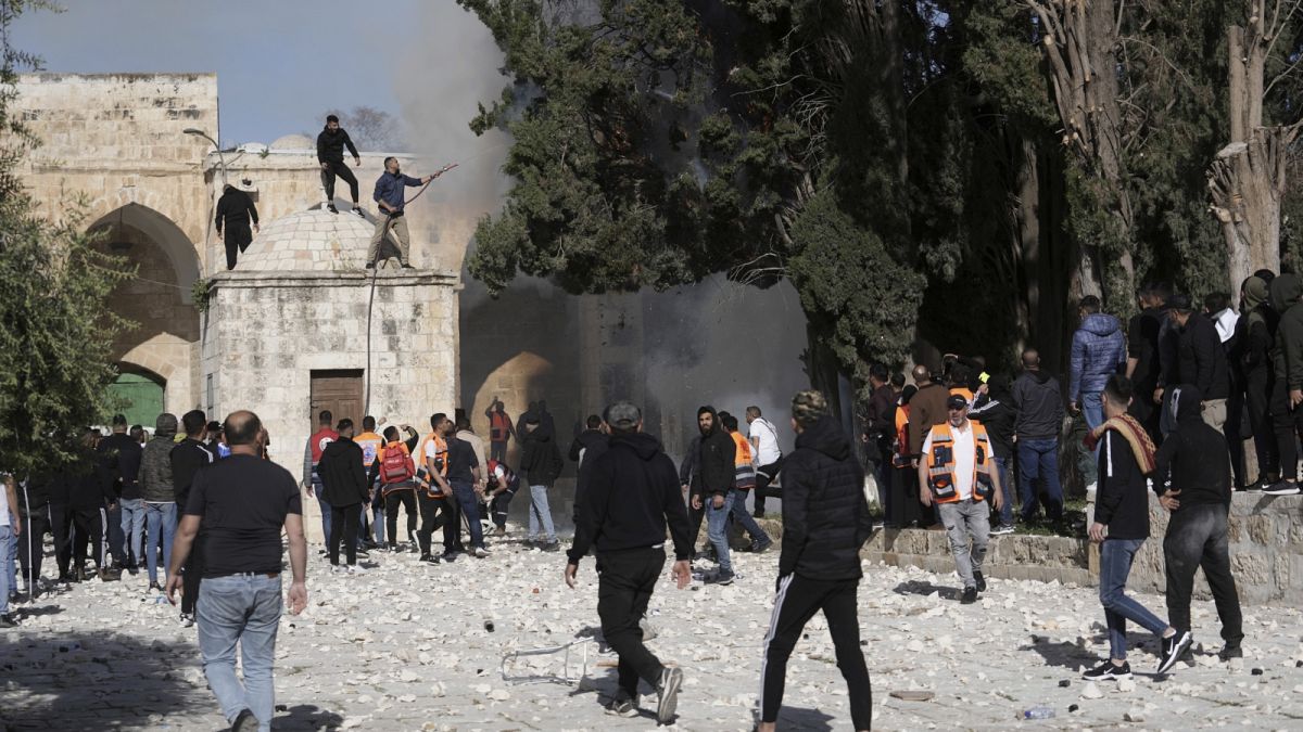Palesztinok próbálnak eloltani egy égő fát az al-Aksza mecsetnél