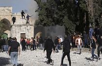 Palesztinok próbálnak eloltani egy égő fát az al-Aksza mecsetnél