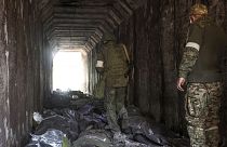 Donyecki orosz fegyveresek nézik ukrán katonák holttesteit Mariupolban