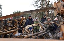 European Council President Charles Michel, center, looks at destroyed vehicles as he is given a tour of the region of Borodyanka, Ukraine, April 20, 2022.