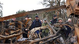 European Council President Charles Michel, center, looks at destroyed vehicles as he is given a tour of the region of Borodyanka, Ukraine, April 20, 2022.