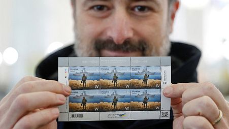 CEO of the Ukrainian post Ihor Smilianskyi demonstrates postal stamps showing Ukrainian service member and Russian warship depicting the sunken cruiser the Moskva.