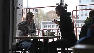 Two Ukrainians sip coffee at a bar in downtown Kyiv.