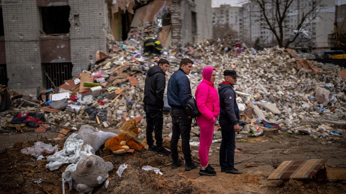 Civilek nézik a lebombázott házukat Csernyihivben, 2022. április 22-én