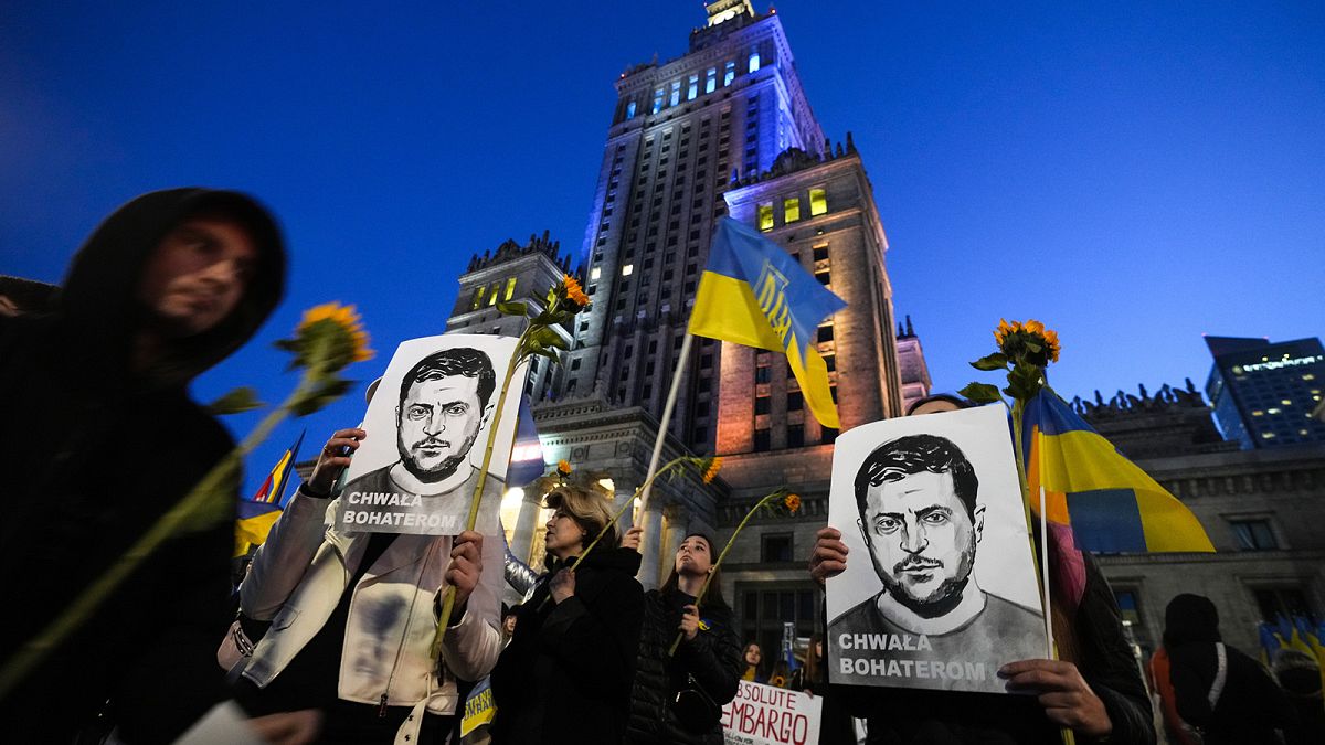 Activist holds portraits of Ukrainian President Volodymyr Zelenskyy during a protest demanding an energy embargo to Russia and the stop of the war in Warsaw, 22 April 2022