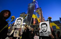 Activist holds portraits of Ukrainian President Volodymyr Zelenskyy during a protest demanding an energy embargo to Russia and the stop of the war in Warsaw, 22 April 2022