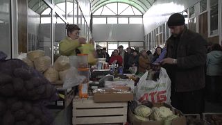 أوكرانيون يشترون احتياجياتهم من الخبز والمواد الغذائية في أحد الأسواق
