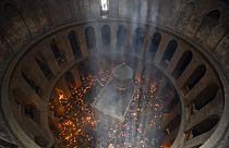 Keresztény zarándokok gyertyát tartanak a Szent Sír-templomban a Szent Tűz szertartásán
