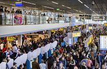 مسافرون ينتظرون في منطقة المطالبة بالأمتعة في مطار سخيبول بالعاصمة الهولندية أمستردام، 23 أبريل 2022.
