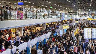  مسافرون ينتظرون في منطقة المطالبة بالأمتعة في مطار سخيبول بالعاصمة الهولندية أمستردام، 23 أبريل 2022.