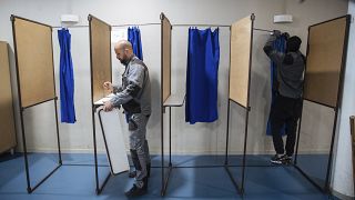 Trabajadores municipales instalan cabinas de votación en un colegio electoral en Montreuil, al este de París, el 23 de abril de 2022.