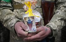 A Ukrainian soldier holds an Easter cake and an icon during a blessing ceremony on Easter eve at a military position outside Kyiv, 23 April 2022