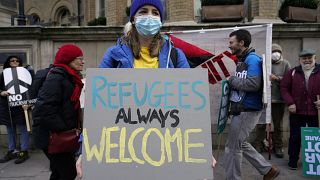 A demonstrator holds a placard saying 'Refugees always welcome' during an anti-war march, in London, Sunday, March 6, 2022.