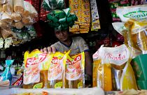 Endonezya'nın başkenti Cakarta'da bir pazardaki tezgahında yemeklik yağ paketlerini gösteren bir satıcı