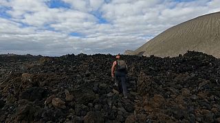 Un científico camina sobre roca volcánica en una de las islas de Revillagigedo, México.