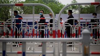 أشخاص يصطفّون في طابور لاختبار الإصابة بفيروس كورونا  في موقع جمع المسحات في أحد شوارع  العاصمة الصينية، بكين، 25 أبريل 2022.