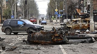 Una parte de un tanque destruido y un vehículo quemado se encuentran en una zona controlada por las fuerzas separatistas respaldadas por Rusia en Mariupol, Ucrania, 23/4/2022