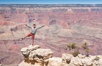 A visitor poses at the Grand Canyon, a popular US tourist spot