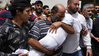 Мужчина держит тело девочки, утонувшей во время крушения судна с мигрантами у ливанского побережья. 25 апреля, 2022 г.