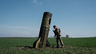 جندي أوكراني ينظر إلى صاروخ باليستي روسي سقط في حقل في بووداروف شرق أوكرانيا. 2022/04/25
