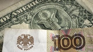 Банкнота в 100 рублей на фоне доллара
