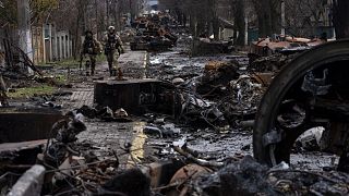 Soldiers walk amid destroyed Russian tanks in Bucha, in the outskirts of Kyiv, Ukraine, April 3, 2022.