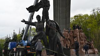Des ouvriers démantelant le monument à Kiev, le 26 avril 2022.